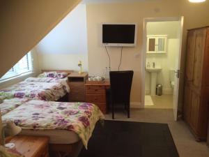 a bedroom with two beds and a tv on the wall at 287 Green Lanes in London