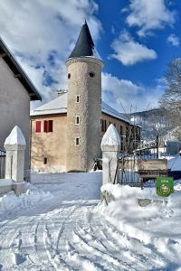 Chateau du Terrail في Montmaur: مبنى فيه برج في الثلج