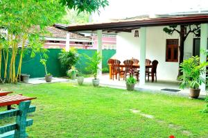 a patio with a table and chairs in a yard at Nethmi Villa in Bentota