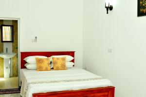 a bedroom with a bed with yellow and white pillows at Nethmi Villa in Bentota