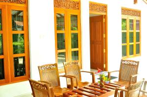 a wooden table and chairs on a patio at Nethmi Villa in Bentota