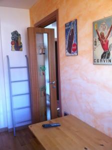 a room with a table and a door with posters on the wall at Torre Dell'orologio Apartment in Sestriere
