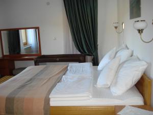 a bedroom with a bed with white sheets and pillows at Villa Una in Sarajevo
