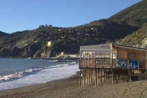 a building on a beach next to the ocean at Affittacamere Il Borgo in Levanto