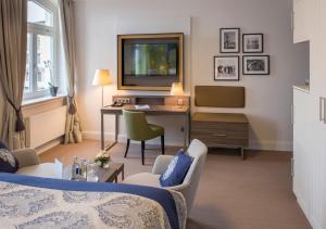 a hotel room with a bed and a desk with a television at Hotel Am Leuchtturm in Warnemünde