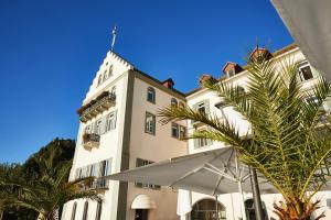 a building with a palm tree in front of it at Steigenberger Inselhotel in Konstanz