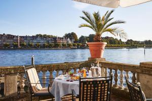 a table with chairs and a plant on a balcony at Steigenberger Inselhotel in Konstanz
