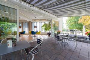 ein Zimmer mit Tischen und Stühlen auf einer Terrasse in der Unterkunft Hotel Vivaldi in Posen