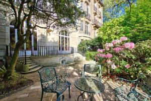 a table and chairs in front of a building at Alfred de Vigny in Paris