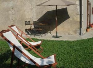 um par de cadeiras e um guarda-chuva em Le Domaine du Grand Cellier Gîtes Appartement en Savoie em Tournon
