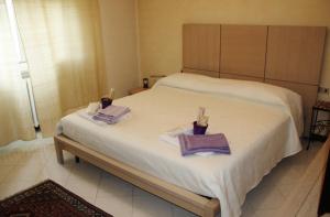 1 Schlafzimmer mit einem großen weißen Bett und 2 Handtüchern in der Unterkunft Villetta Il Glicine in Porto Mantovano