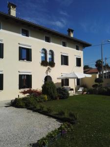 a large white house with a lawn in front of it at Casa Zanier Aviano in San Martino