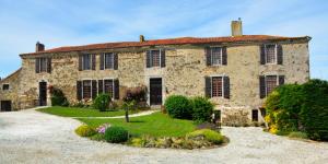 an old stone house with a garden in front of it at Chambre d'hôte Manoir de La Baudonnière in Monsireigne