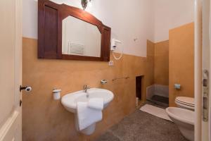 a bathroom with a sink and a mirror and a toilet at Palazzo Laura in Morciano di Leuca +74 photos