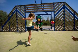 Ein junges Mädchen spielt mit einem Ball in einer Turnhalle in der Unterkunft Camping Officiel Siblu Les Dunes de Contis in Saint-Julien-en-Born