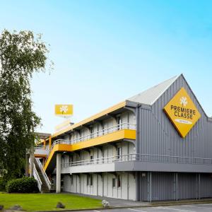 un bâtiment avec un panneau jaune sur son côté dans l'établissement Premiere Classe Lyon Ouest - Tassin, à Tassin-la-Demi-Lune