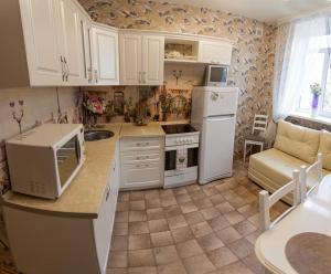 una cucina con armadietti bianchi e frigorifero bianco di Apartment on Lenina 69А a Tyumen