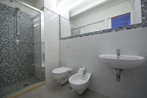 a bathroom with a sink and a toilet and a shower at Casa Bova in Mesagne +10 photos