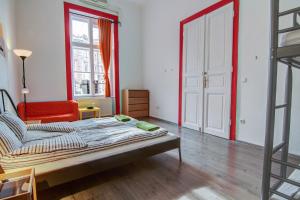 a bedroom with a bed and a red chair at Pal's Mini Hostel in Budapest