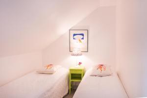 2 camas individuais num quarto no sótão com um candeeiro. em Eneby Gård Apartments em Sköldinge