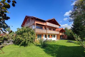 a large house with a green yard in front of it at Apartements Luna Blanca in Schwangau
