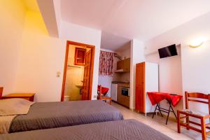 Dormitorio pequeño con 2 camas y cocina en Balaskas Hotel en Diafani