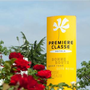 un signe jaune avec une fleur à côté des fleurs rouges dans l'établissement Premiere Classe Mulhouse Sud Morschwiller, à Morschwiller-le-Bas