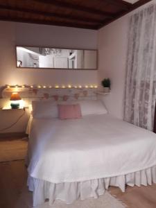 Un dormitorio con una cama blanca con luces encima. en Loft PapaPepe en Arucas