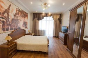 a bedroom with a large bed and a television at Apartment on Lenina 69А in Tyumen