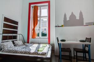 a bedroom with a bed and a table and a window at Pal's Mini Hostel in Budapest