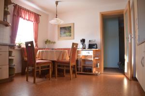 cocina y comedor con mesa y sillas en Ferienwohnung Elisabeth, en Klingenthal