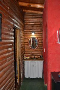 uma casa de banho com um lavatório num chalé de madeira em Mainame Traslasierra em Los Hornillos