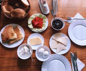 un tavolo in legno con piatti di cibo sopra di Hotel Lileo a Mestia