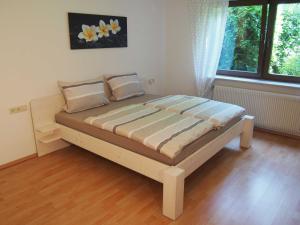 a bed in a bedroom with a wooden floor at Ferienwohnung naehe Freiburg FeWo in Holzhausen