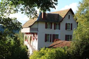 a white house with red windows and a roof at La maison de Lilou in Malbuisson +14 photos