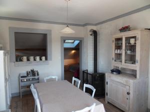 a dining room with a table and a stove at La maison de Lilou in Malbuisson