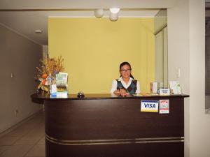 a woman is sitting at a reception desk at Majestuoso Hospedaje in Tacna