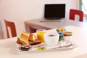 a breakfast tray with toast and coffee and orange juice at Hôtel Premiere Classe Pamiers in Pamiers