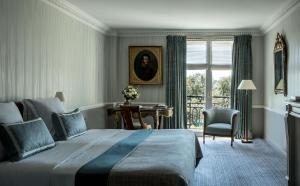 a bedroom with a bed and a desk and a window at Hôtel Brighton - Esprit de France in Paris