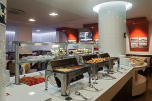 a buffet line with many different types of food at Normandy Hotel in Belo Horizonte