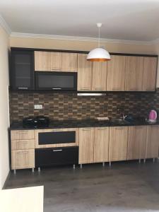 una cocina con armarios de madera y electrodomésticos negros en Modern Apartments en Mukacheve