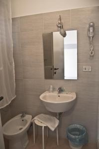 a bathroom with a sink and a mirror and a toilet at Albergo La Marinella in Varazze