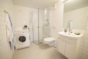 a bathroom with a toilet sink and a washing machine at BJØRVIKA APARTMENTS, Teaterplassen, Oslo city center in Oslo