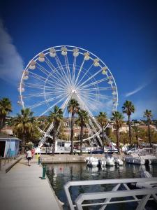 une grande roue ferris dans un port de plaisance avec des bateaux dans l'établissement Les Terrasses, à Bormes-les-Mimosas