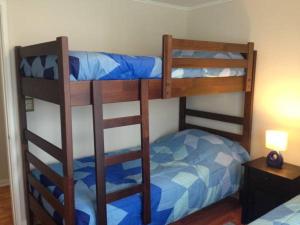 1 dormitorio con 2 literas y 1 cama azul en Mirador Villarrica Apartment, en Villarrica