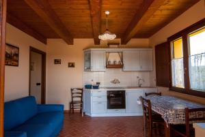 a kitchen with a blue couch and a table at Country House Il Tiglio in Mergo