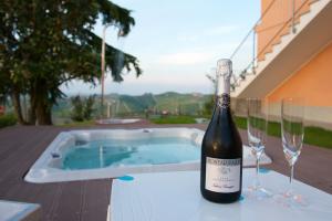 a bottle of wine and two wine glasses on a table at Bella Vista Barbaresco in Barbaresco