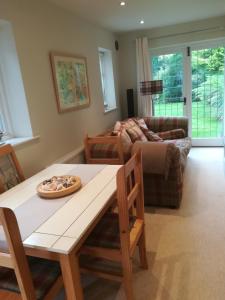 a living room with a table and a couch at The Gate Cottage in West Itchenor
