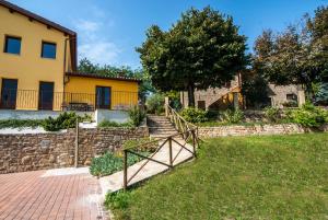 a house with a staircase in front of a yard at Country House Il Tiglio in Mergo