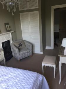 um quarto com uma cama, uma cadeira e uma lareira em Braeside em Alnwick